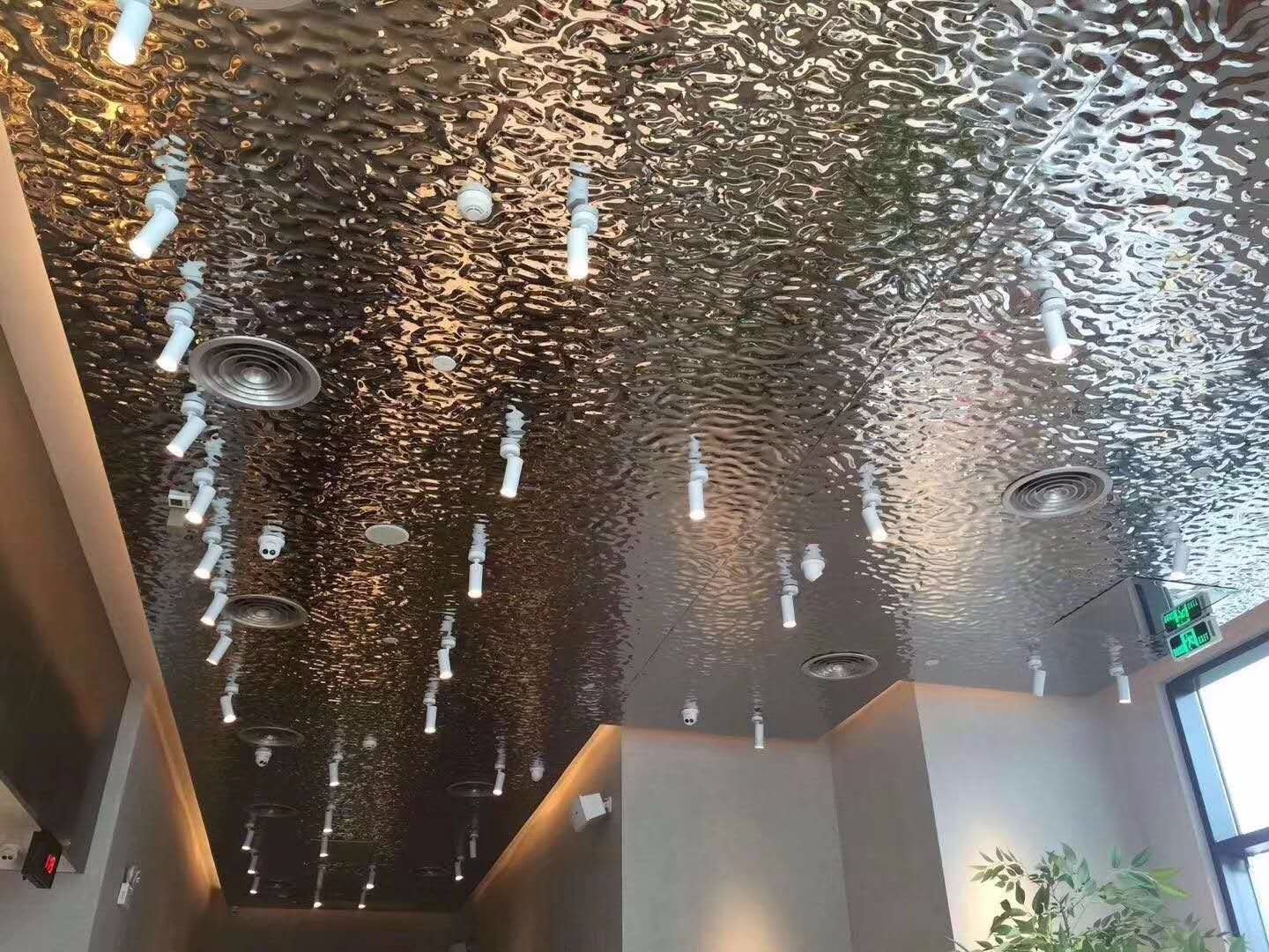 Ripple-textured stainless steel ceiling with integrated lights